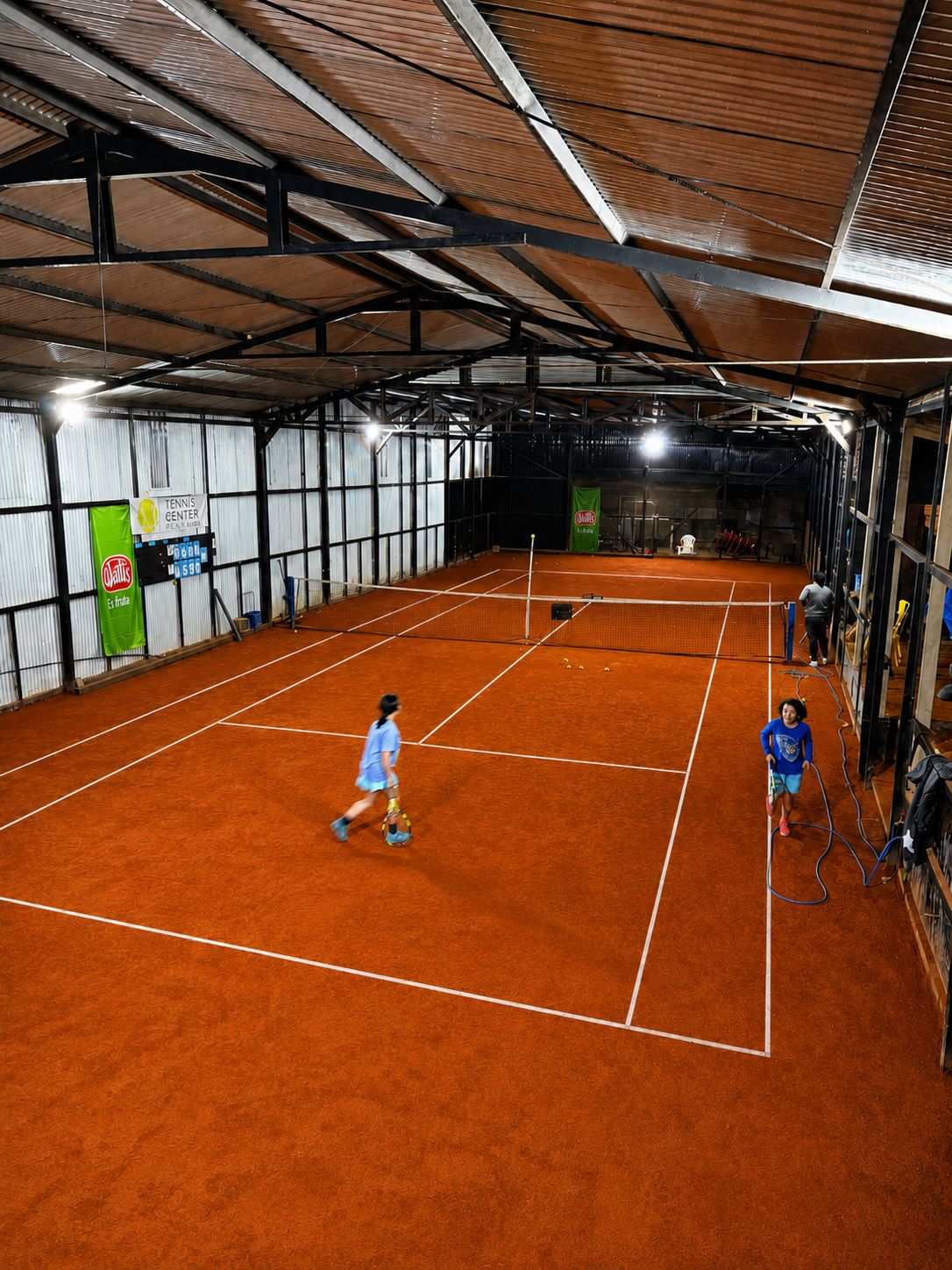 Cancha de tenis bajo techo con jugadores